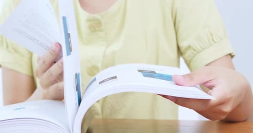 A person enjoys flipping through a magazine in a cozy home environment.
