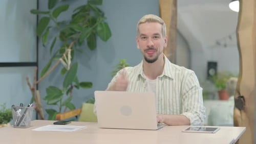 Man Working on Laptop Gives Thumbs Up