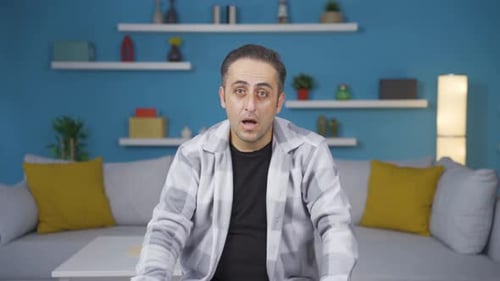 Man Reacts with Surprise and Joy Indoors