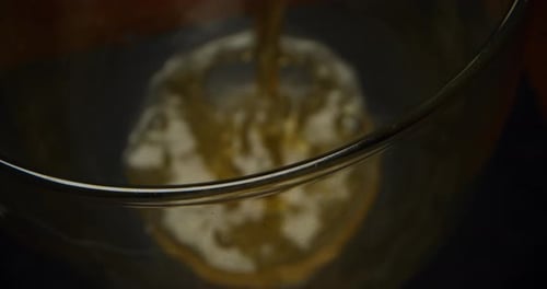Close up of some beer in a glass with a nice white foam on a black background. Concept: food and d