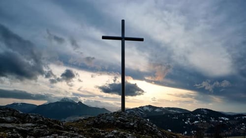 Christian Cross on a Rock in a Mountain Landscape Clouds Over the Silhouette of the Mountains