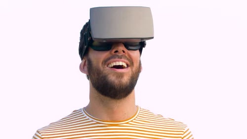 Un jeune homme souriant aime jouer à la réalité virtuelle en plein air avec un casque futuriste