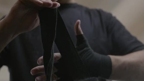 Man Wraps His Hands with Boxing Bandages Kickboxing Training Day in a Gym Slow Motion
