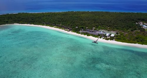 Soft wide panoramic bird's eye view over secluded Maldives island and resort. Bright sunny day, whit
