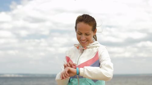 Sporttechnologie und Konzept für einen gesunden Lebensstil - Lächelnde Frau mit Fitness-Tracker