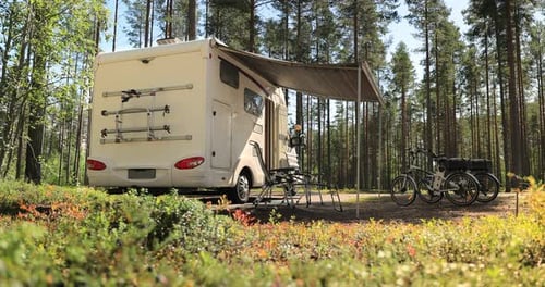 Scenic Forest Campsite with Camper and Bicycles