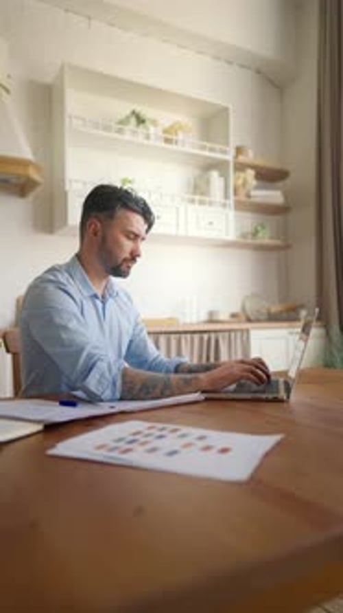 Man Working at Wooden Table at Home