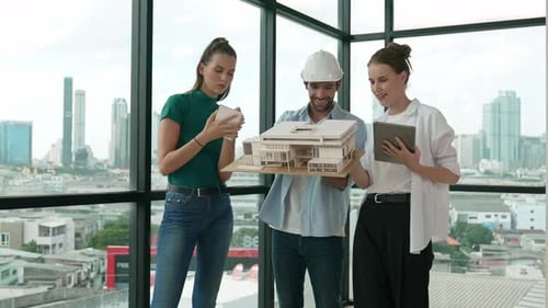Architects Review Building Model in Modern Office