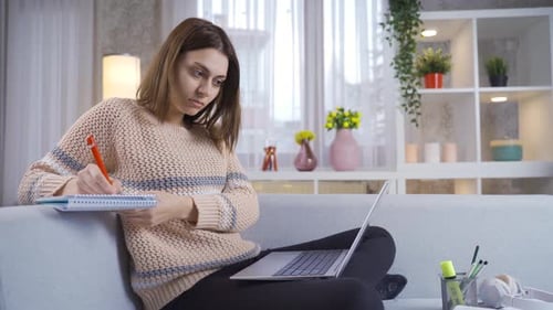 Woman Studying with Laptop and Notebook at Home