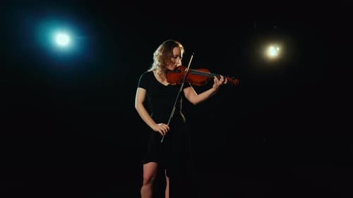 Woman Playing the Violin on a Dark Stage