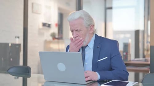 Coughing Old Businessman Using Laptop in Office