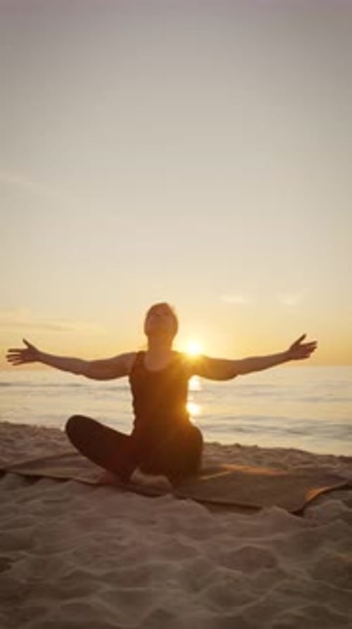 Woman Practicing Yoga on Beach at Sunrise