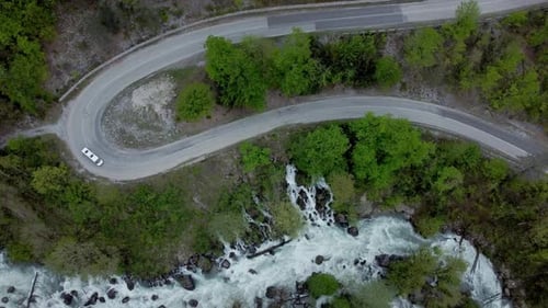 Above View of Car Drives Along Winding Countryside Road Irrl