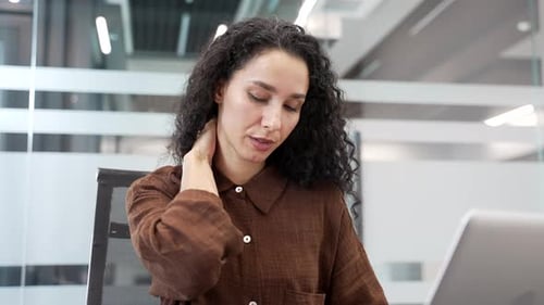 Woman Rubbing Sore Neck at Workplace