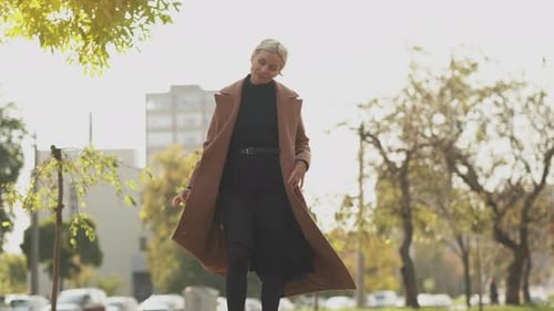 Stylish Woman Walks in an Urban Park