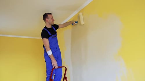 Young colorist doing new renovation in house. Painter decorating with color indoor.