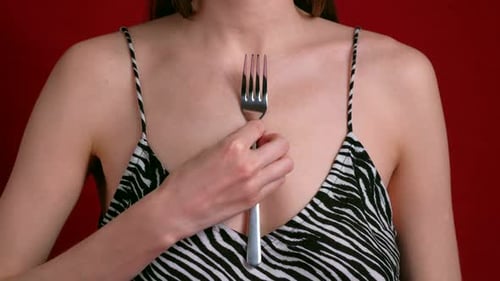 Femme magnétique avec des cuillères attachées à sa peau