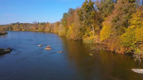 Beautiful autumn river drone view. Orange colors landscapes aerial view.