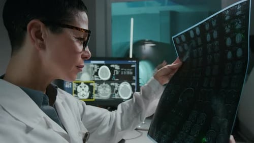 Female Radiology Specialist Scrutinizing Brain MRI on Film