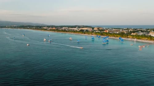 Traditionelle blaue Segelboote in der Nähe eines tropischen Strandes bei Sonnenuntergang auf der Insel Boracay, Philippinen