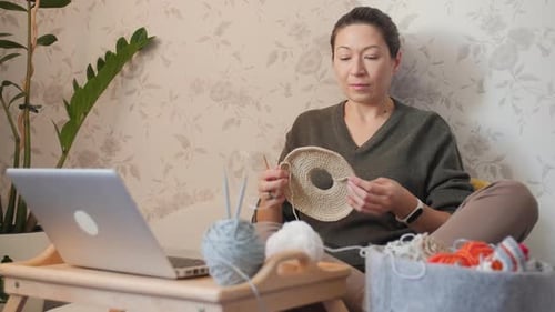 Woman Crocheting a Tan Project Indoors