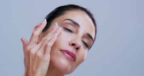 Apply cream, skincare and woman in studio for anti aging, skin hydration