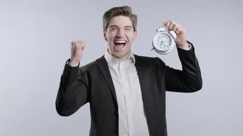 Glücklicher Geschäftsmann mit Uhr auf weißem Hintergrund Ende des Arbeitstages im Büro