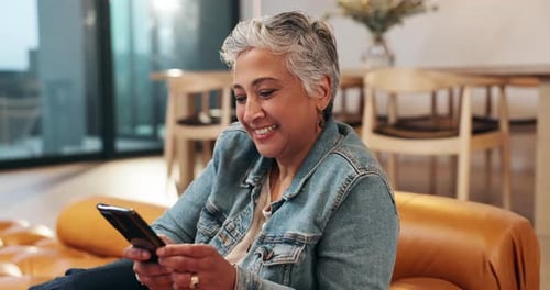 Smiling Senior Woman Using Smartphone on Couch