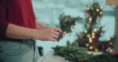 Assembling Christmas Arrangement with Pine Needles Indoors