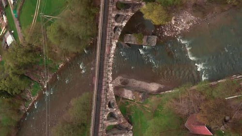 Countryside landscape with mountain river and old viaduct railroad bridge