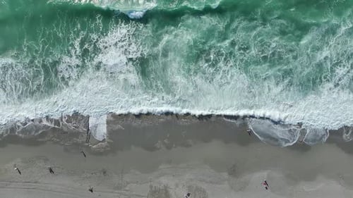Aerial Video Stunning Foam Trails Left By Crashing Storm Waves on the Scenic Beach