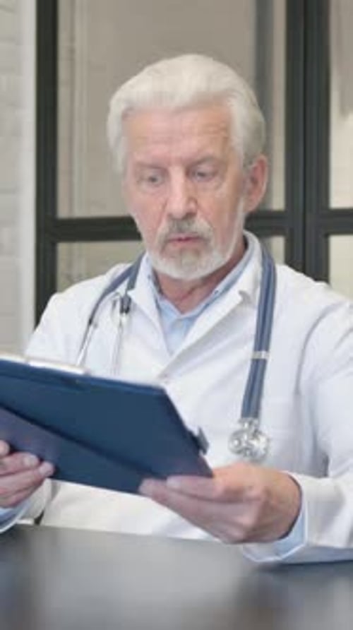 Senior Doctor Discussing Medical Report with Patient