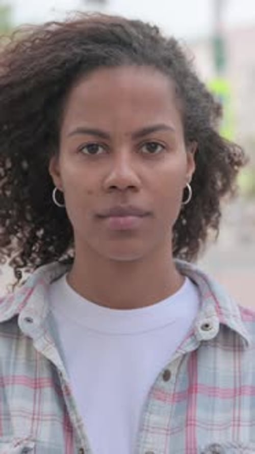 Porträt einer Afrikanerin, die im Freien in die Kamera schaut, vertikales Video