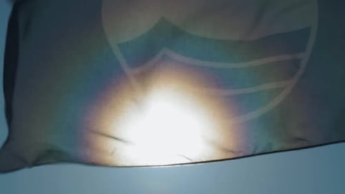 Sonnenfahne flattert im Wind vor der Sonne