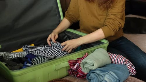 Adult Packing Suitcase at Home for Trip