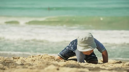 Child Playing With Toys on Sandy Beach During Sunny Day