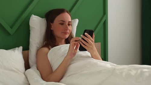 Woman in Bed Using Smart Phone