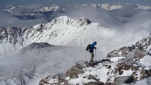 Winterwandern und herrlicher Blick auf die schneebedeckte Bergkette. Ein Mann, der auf High Elev auf den Gipfel
geht