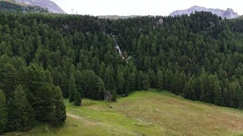 Aerial View of Tranquil Waterfall and Verdant Forest near Silvaplana