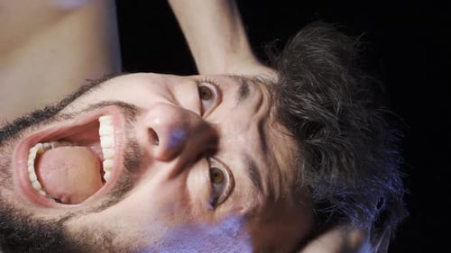 Man Yelling in Distress and Surrounded by Hands