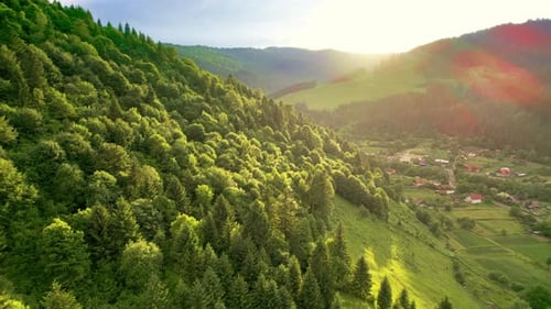 Aerial drone view of nature in the Carpathians in Romania. Village located in a valley, hills covere