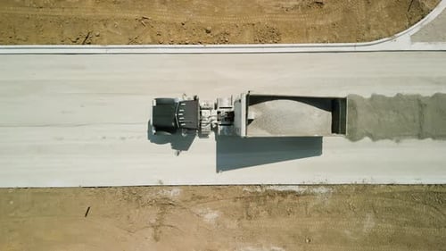 Construction Truck Tipping Dumping Gravel on Road Construction Site Aerial Top Shot