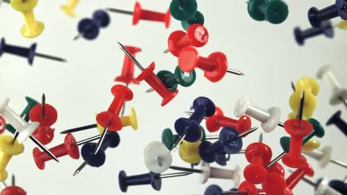 Colorful Push Pins Floating in Air on White Background