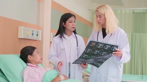 Female doctors explain X-ray film to a patient in a hospital.