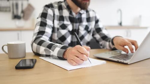 Close Up of Hand of Businessman with Pen Making Notes on Draft of Paper