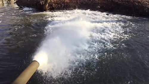 Slow Motion Water Pours From An Iron Rusty Pipe. Water Pollution, River Pollution, Dirt