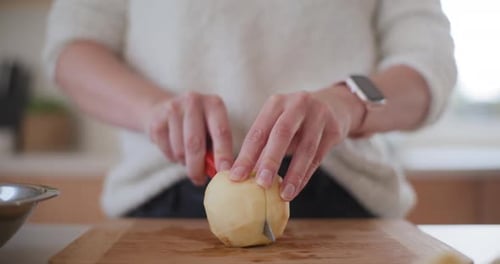 Woman Peels Apples In Kitchen