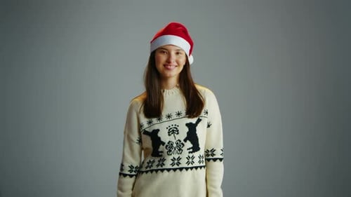 Woman in Red Santa Hat Christmas Sweater Posing Gray Isolated Studio Background
