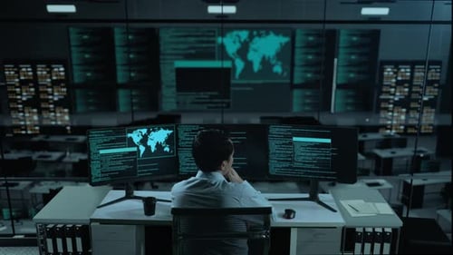 Asian Man Thinking About Something While Write Code With Multiple Computer Screens In office