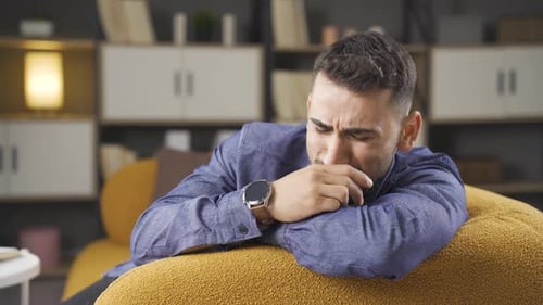 Distressed Man Lying on Cushion Indoors